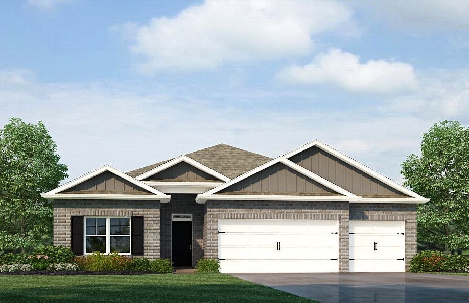 A single-story brick house with a two-car garage and gabled roof under a cloudy blue sky.