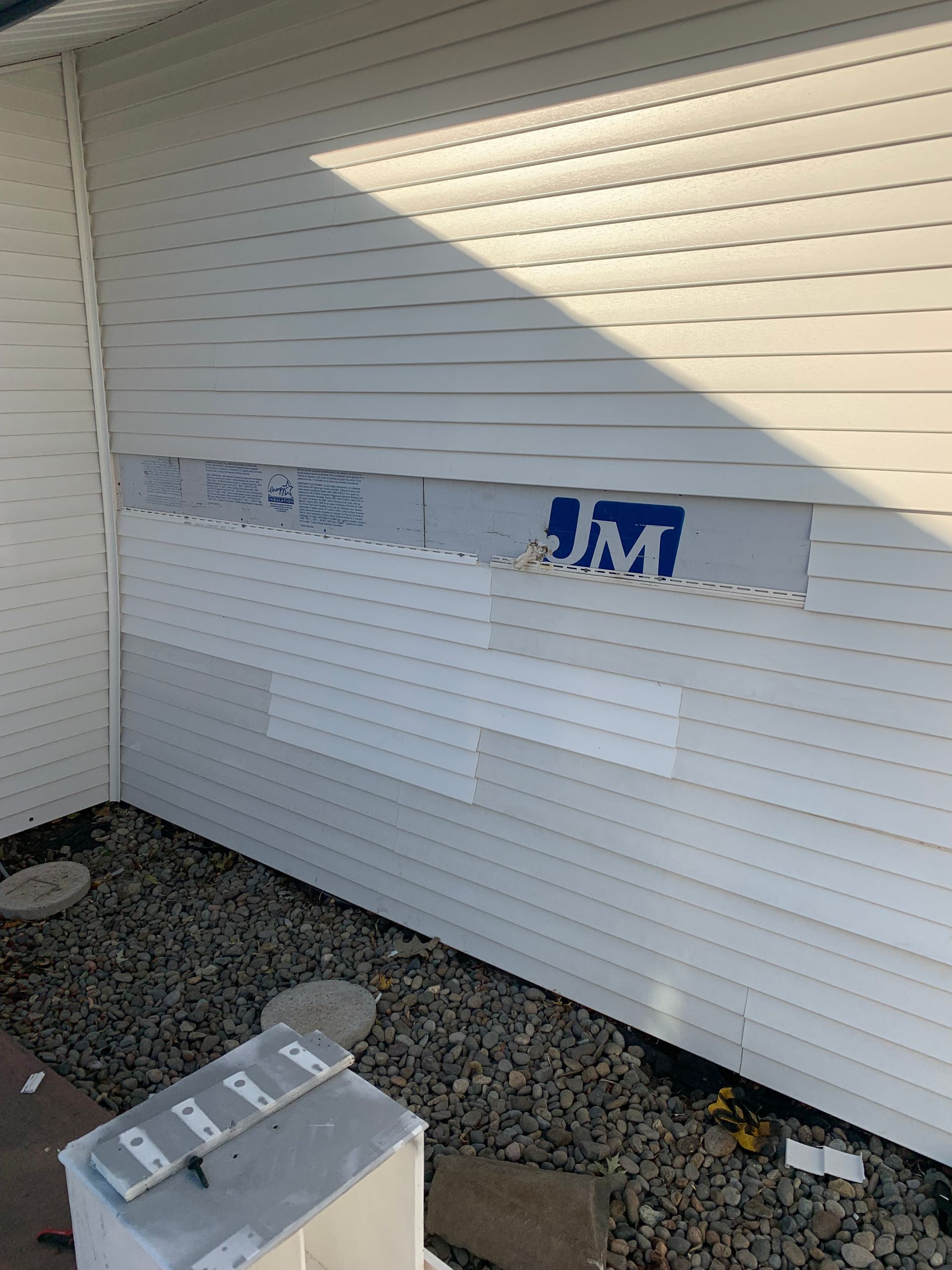A photo of a vinyl siding repair in progress. 