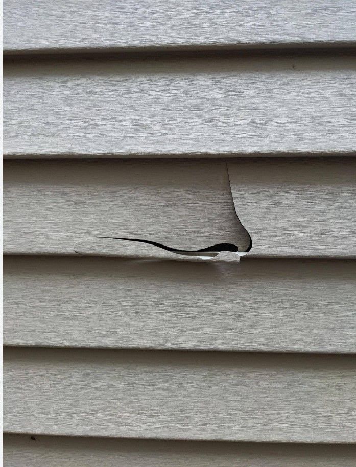 A photo of vinyl siding that is cracked