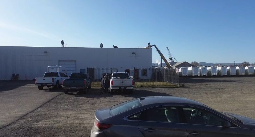 Telehandler lift assisting in material handling during OSB resheeting at Decco USA roofing project in Yakima.