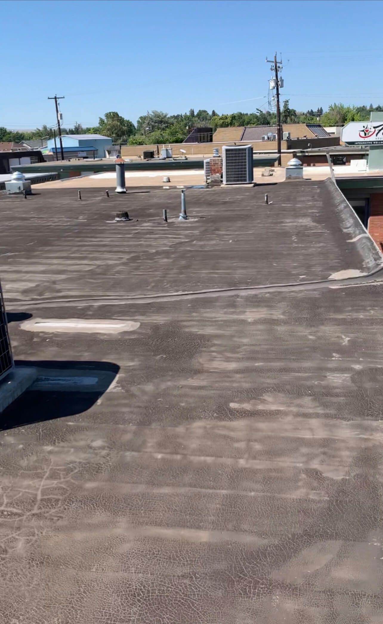 Cracked and weathered built-up roof system on Labcorp building in Yakima before tear-off and TPO installation.