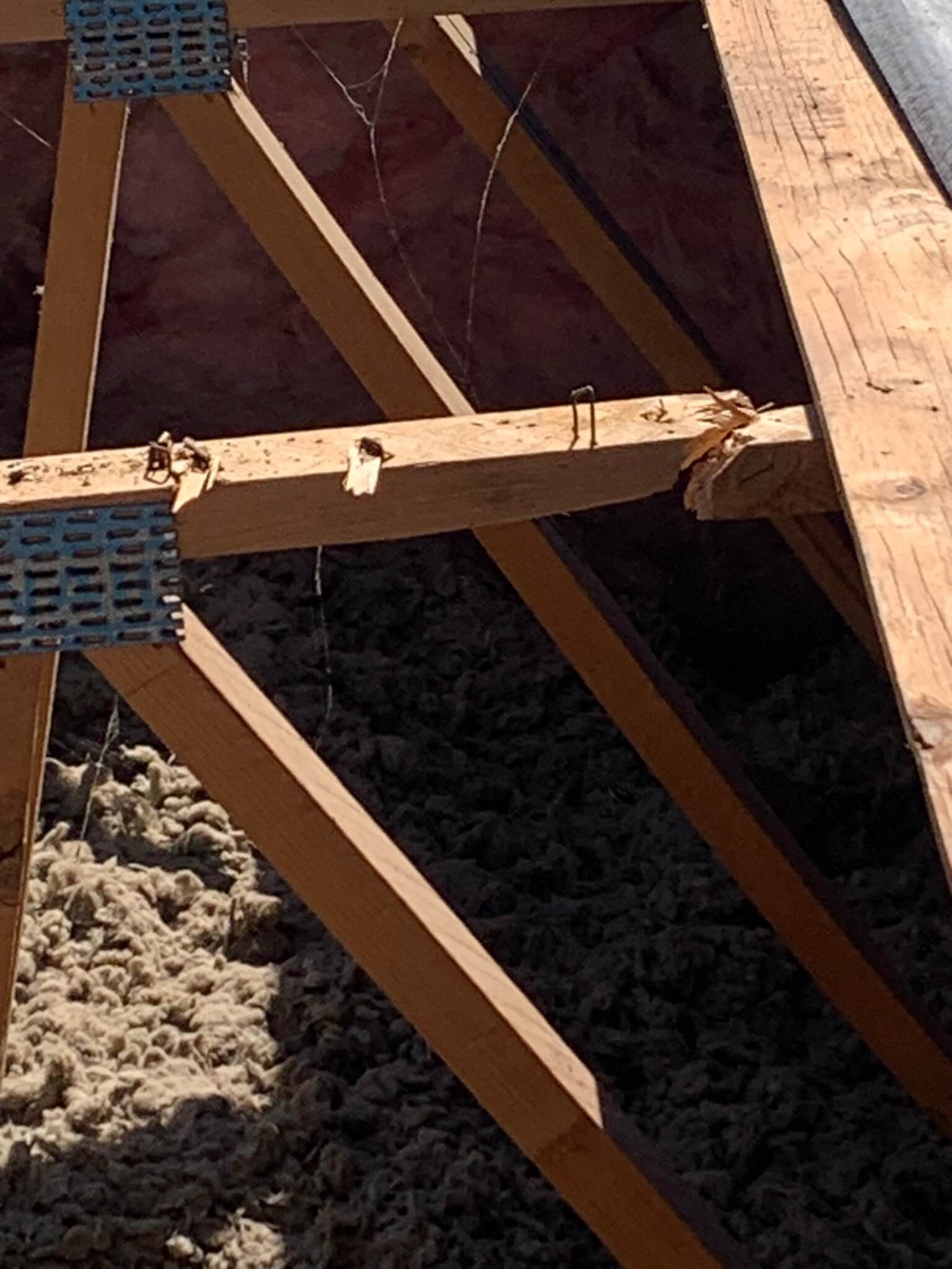 Cracked wooden truss in a manufactured home roof structure, prepared for repair.