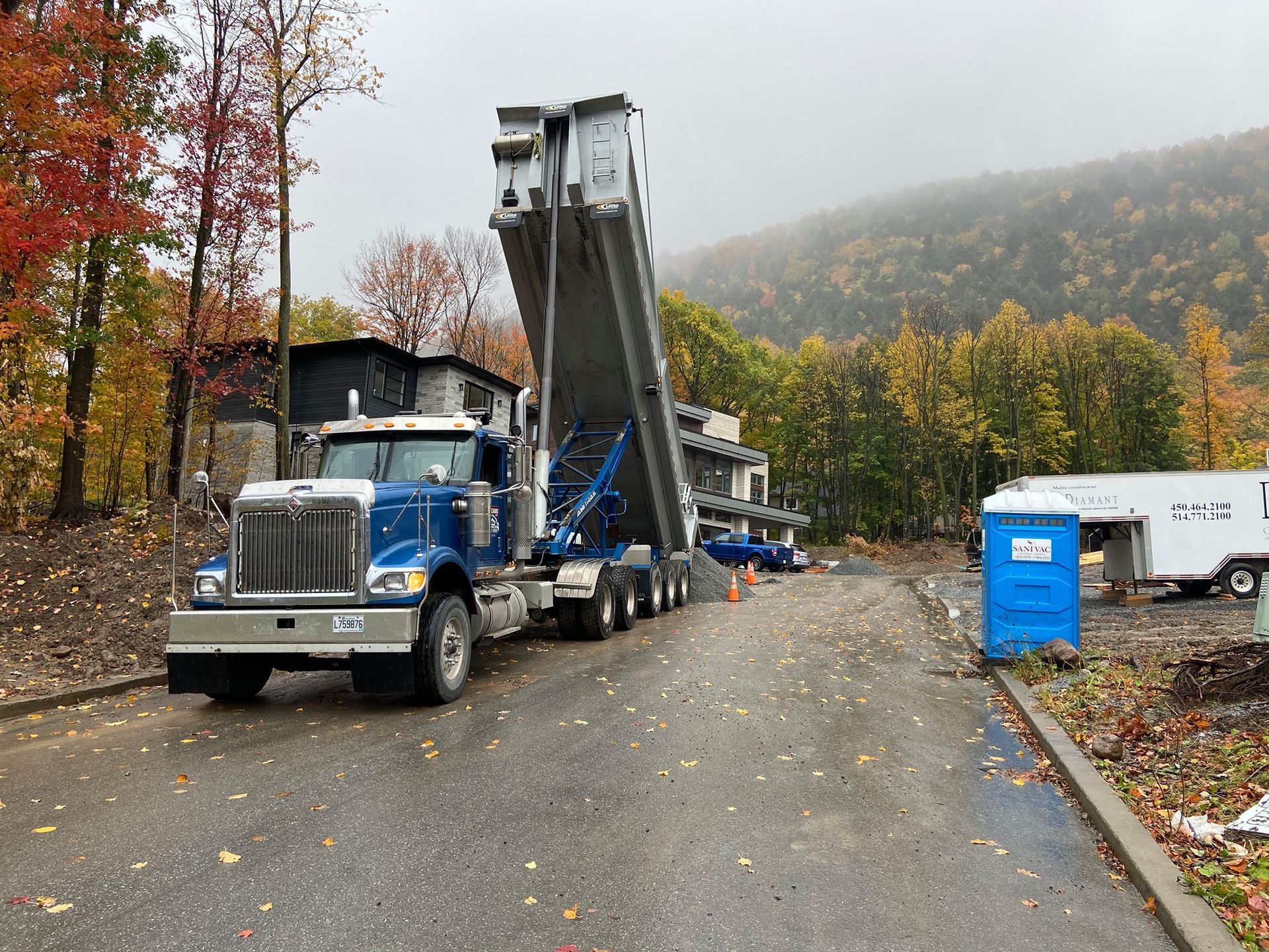 Un camion-benne bleu est garé sur le bord d'une route.