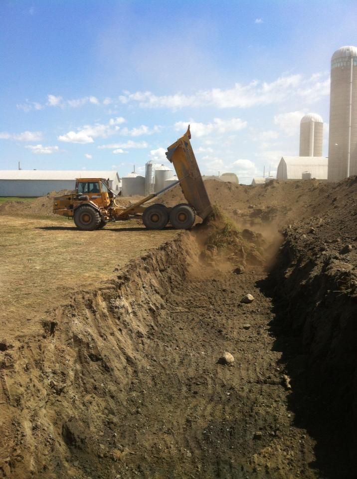 Un camion à benne basculante traverse un champ de terre.