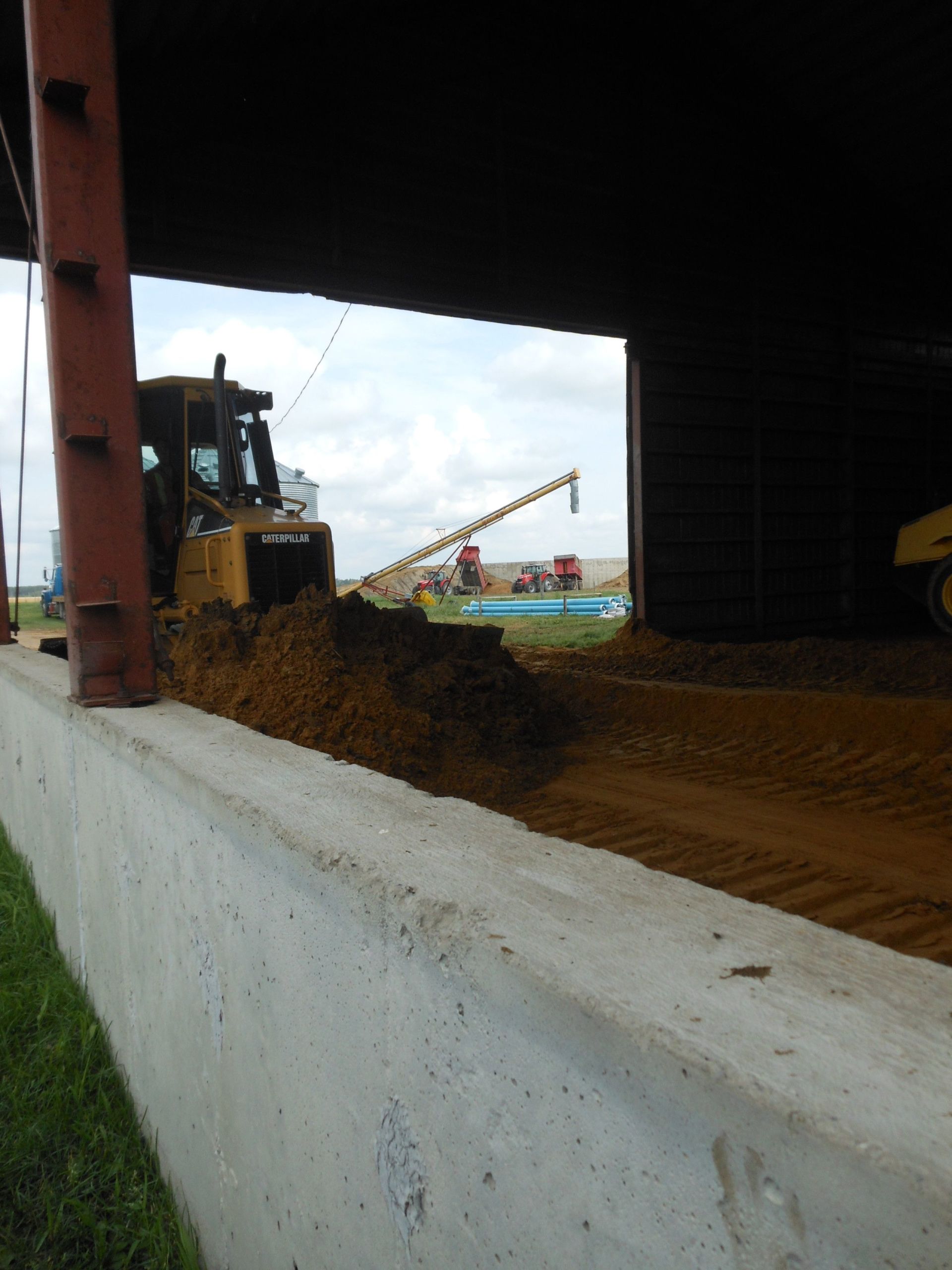 Un bulldozer déplace de la terre devant un bâtiment
