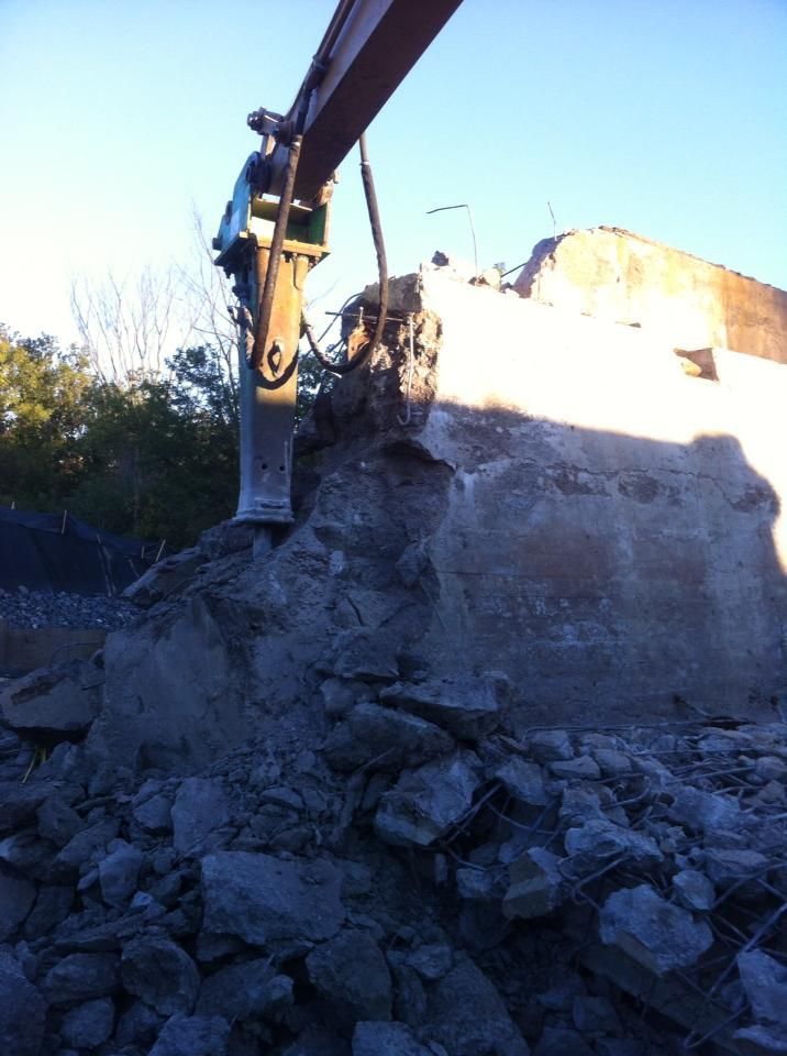 Un gros tas de roches est soulevé par une excavatrice