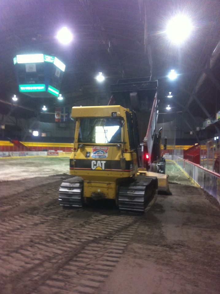 Un bulldozer jaune roule sur un chemin de terre
