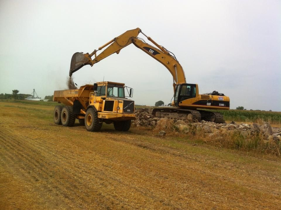 Un bulldozer charge de la terre dans un camion à benne basculante