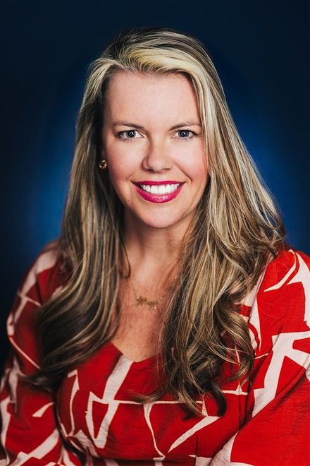 A woman in a red and white dress is smiling for the camera.