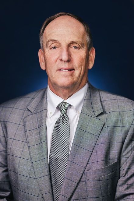 A man in a suit and tie is smiling for the camera.