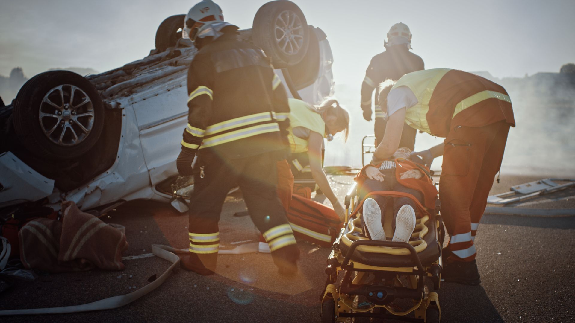A group of firefighters are rescuing a person from a car accident.