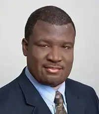 a man in a suit and tie is smiling for the camera .