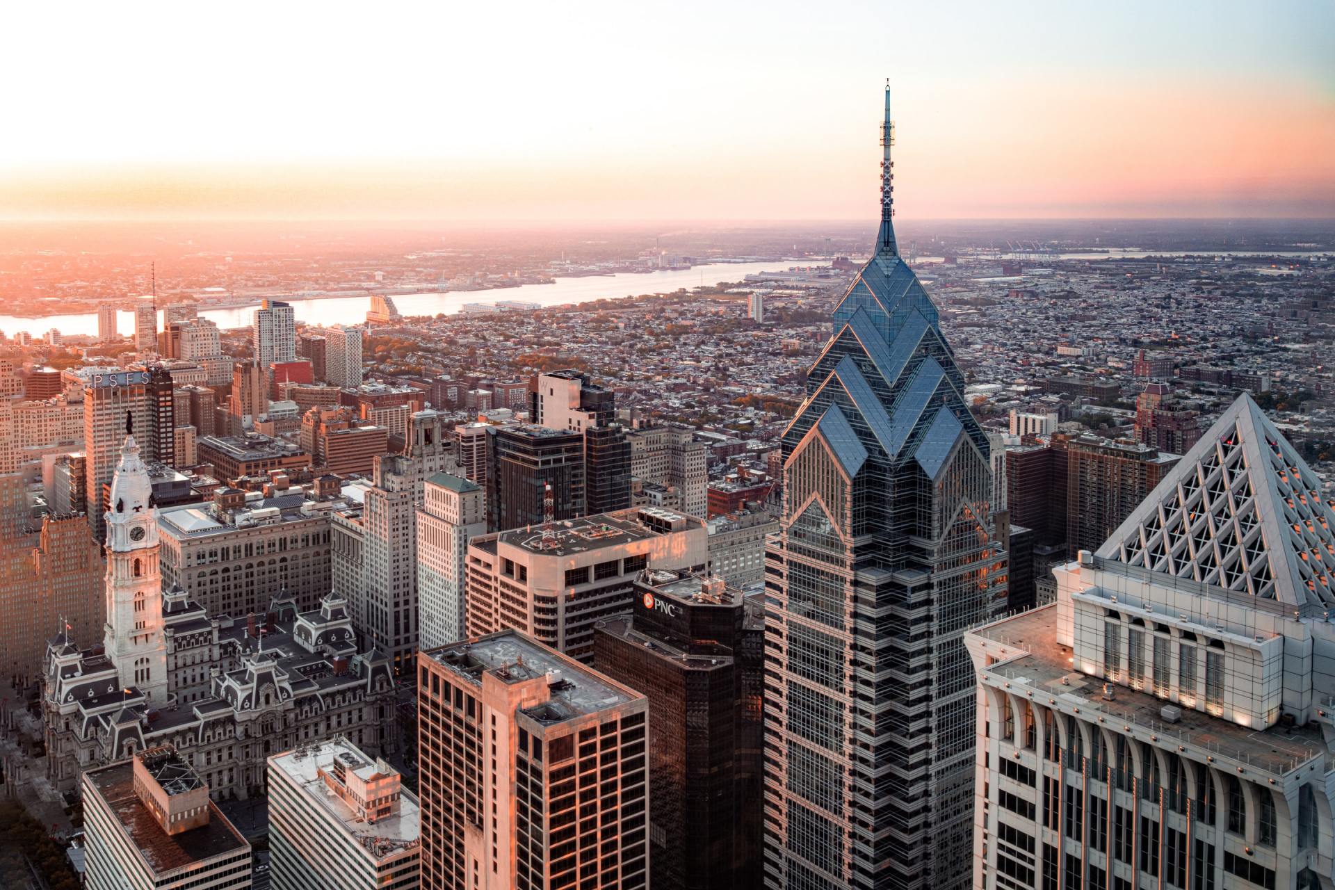 an aerial view of a city skyline at sunset with a large building in the foreground .