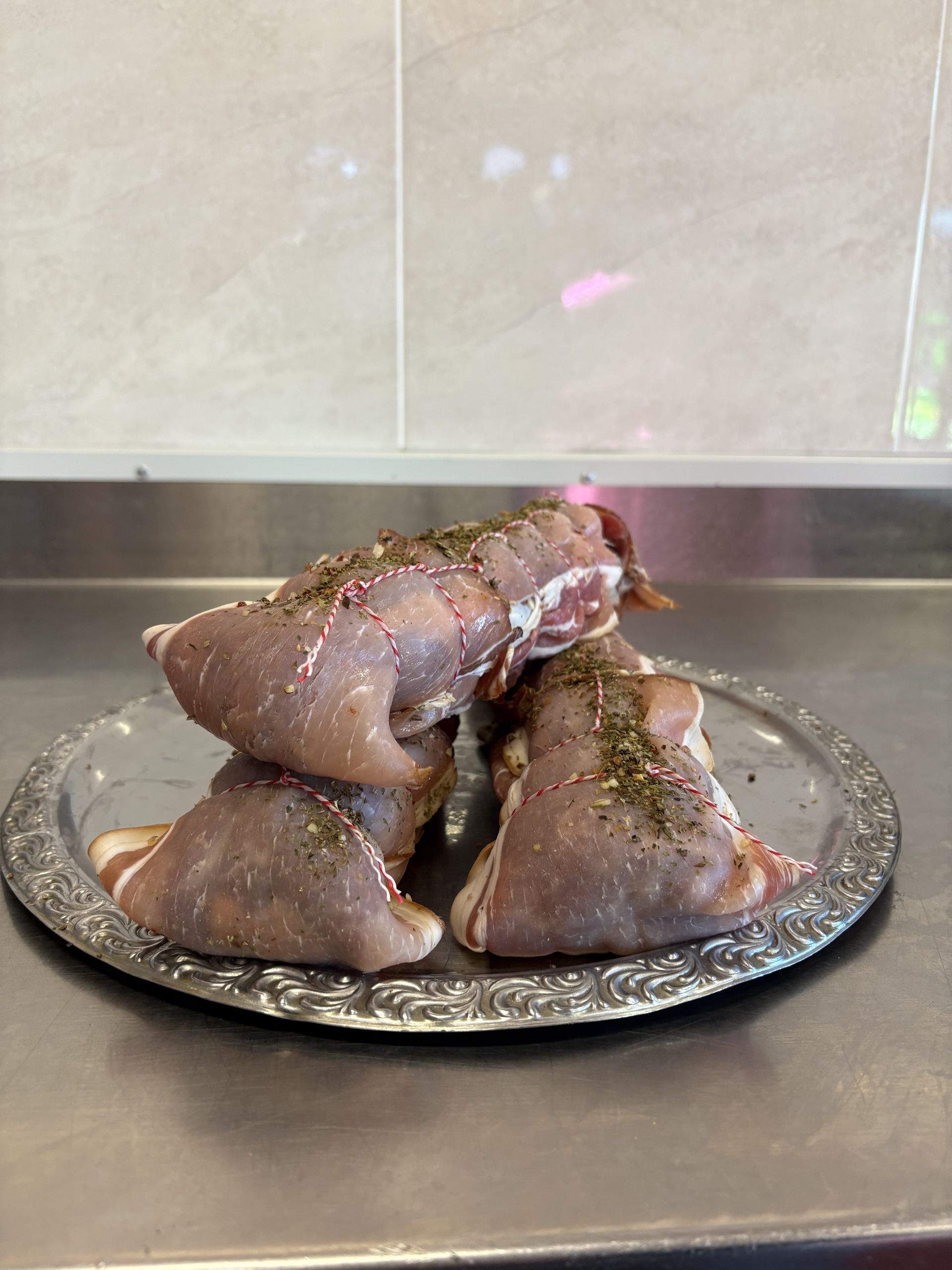A Sliced Ham Is Sitting on A Wooden Cutting Board Next to Garlic and Potatoes — Mentges Master Meats Traditional Continental Smallgoods In Taree, NSW