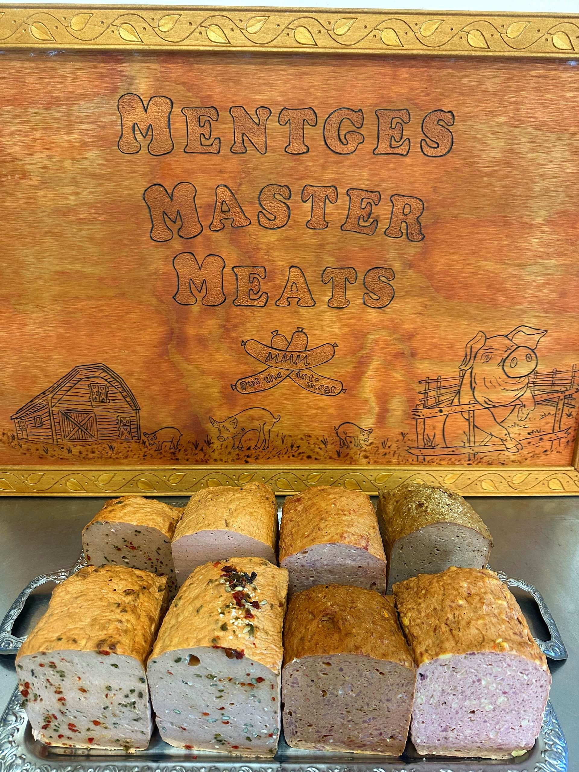 A Loaf of Meatloaf Is Sitting on A White Plate with Slices Taken out Of Sit — Mentges Master Meats Traditional Continental Smallgoods In Taree, NSW