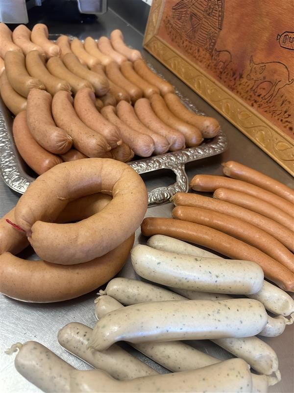 A Bunch of Sausages Are Cooking on a Grill — Mentges Master Meats Traditional Continental Smallgoods In Taree, NSW