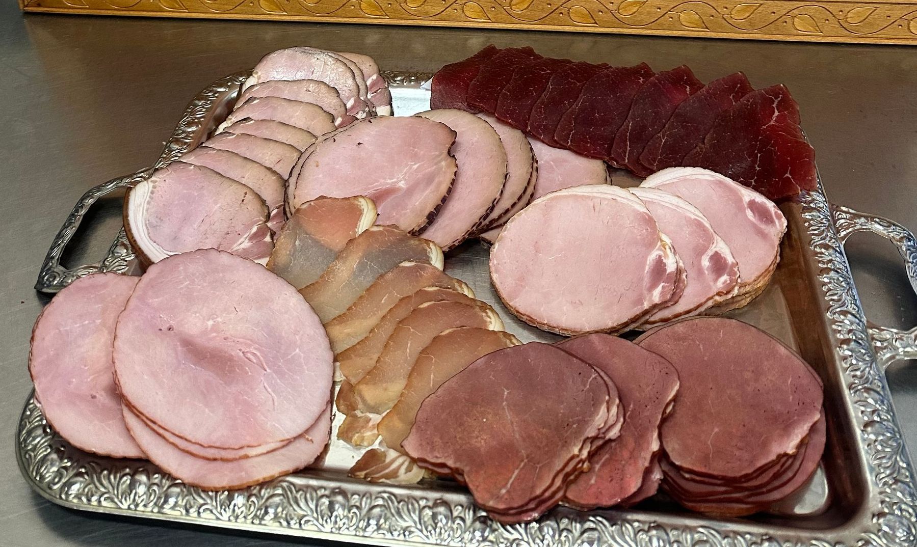 A Large Piece of Ham Is Sitting on A Wooden Cutting Board —Mentges Master Meats Traditional Continental Smallgoods In Taree, NSW