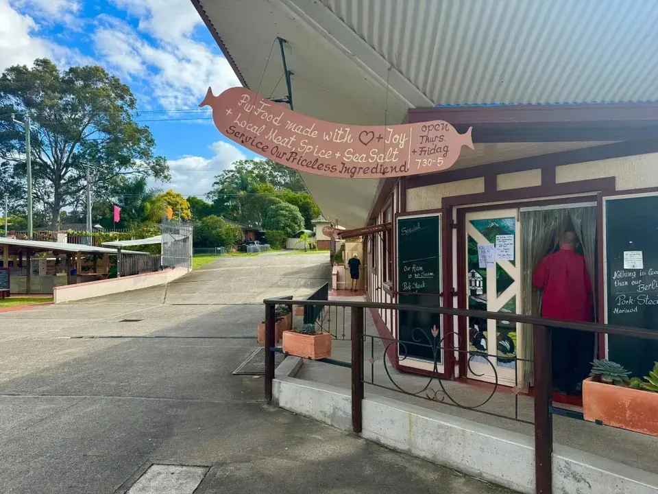 A White Plate Topped with Grilled Sausages with Sauce on Them — Mentges Master Meats Traditional Continental Smallgoods In Taree, NSW