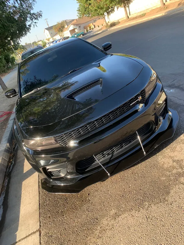 Black Dodge Charger parked on a city street, facing the camera.