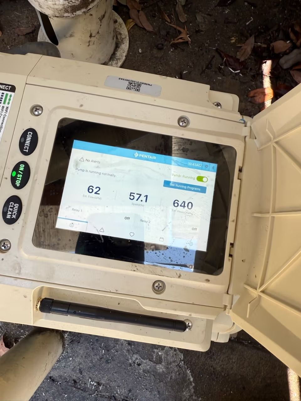 Open, tan-colored outdoor device with a screen showing numbers. Top section open.