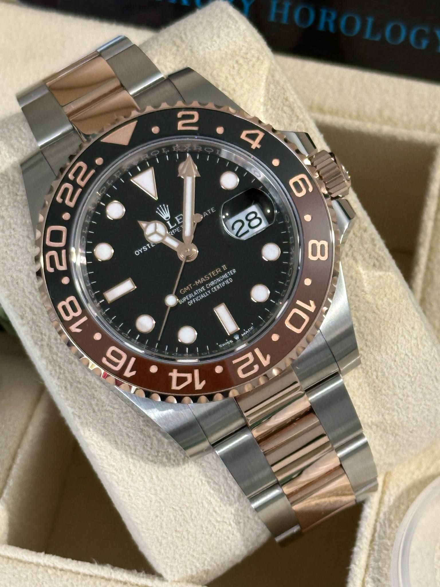 A rolex watch is sitting on top of a white cushion.