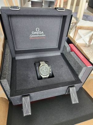A omega watch is sitting inside of a black box.