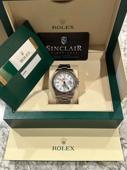 A rolex watch is in a box with a certificate.