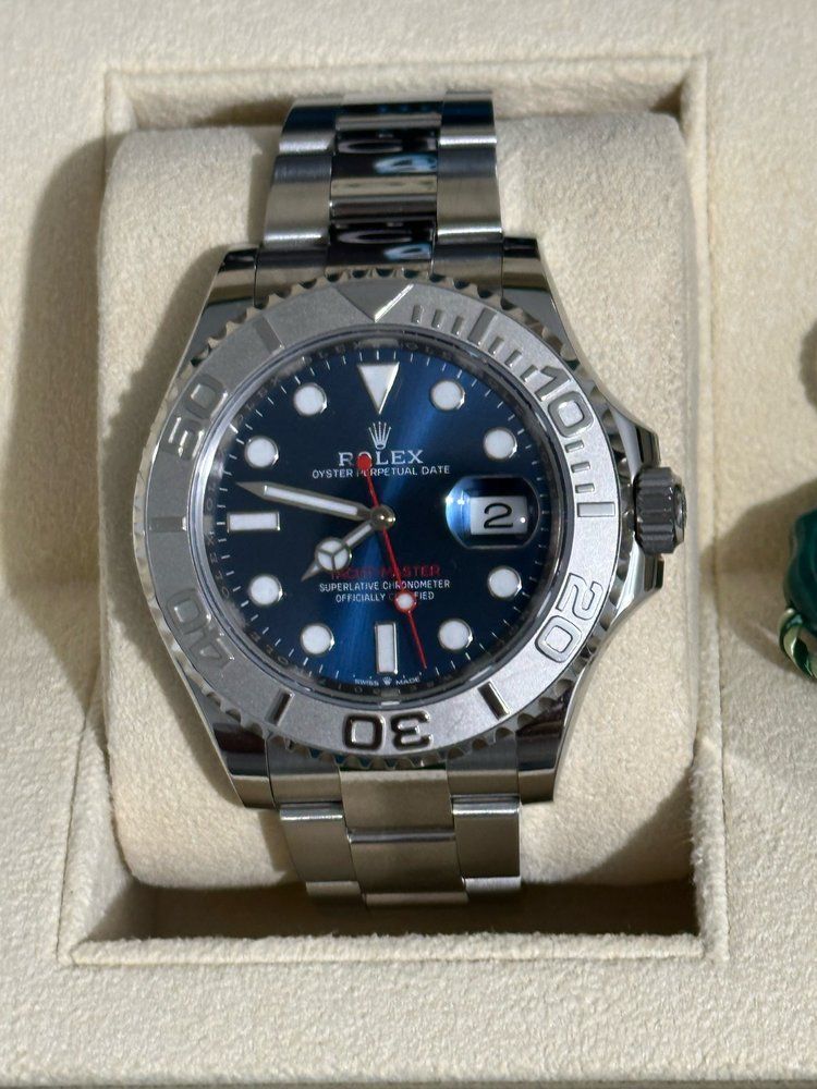 A silver rolex watch with a blue face