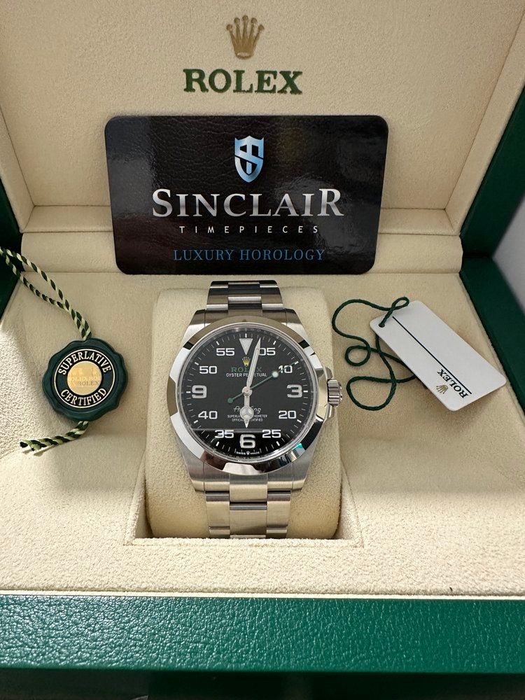 A rolex watch is in a box with a sinclair card