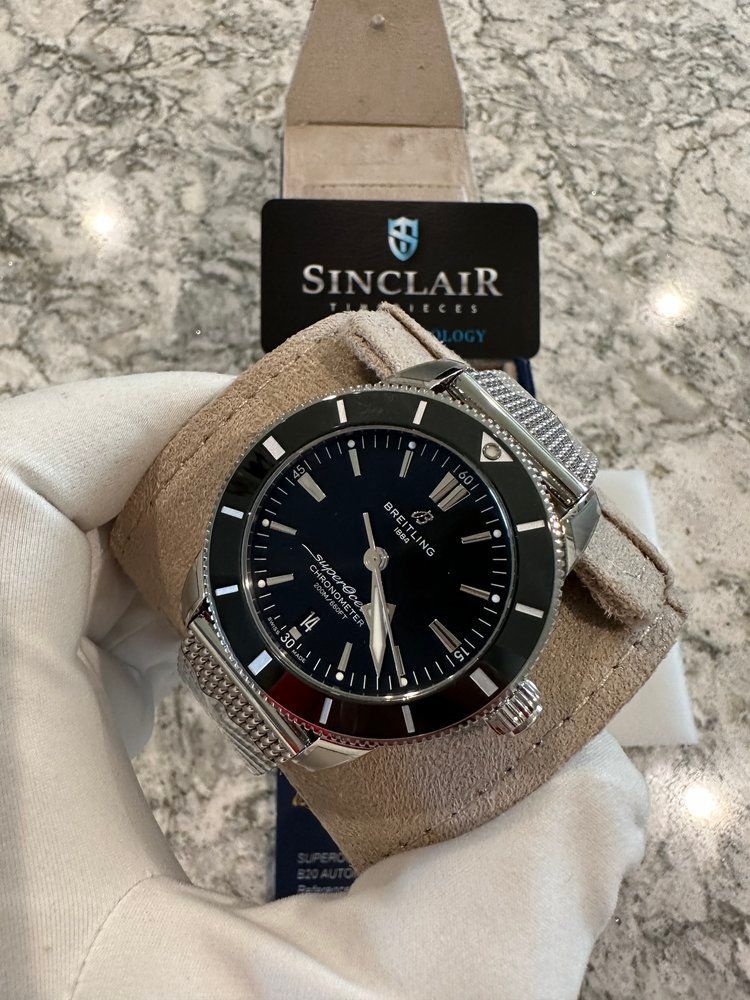 A person is holding a sinclair watch in their hand