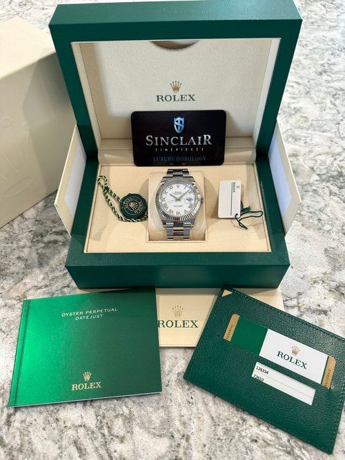 A rolex watch in a box with a certificate