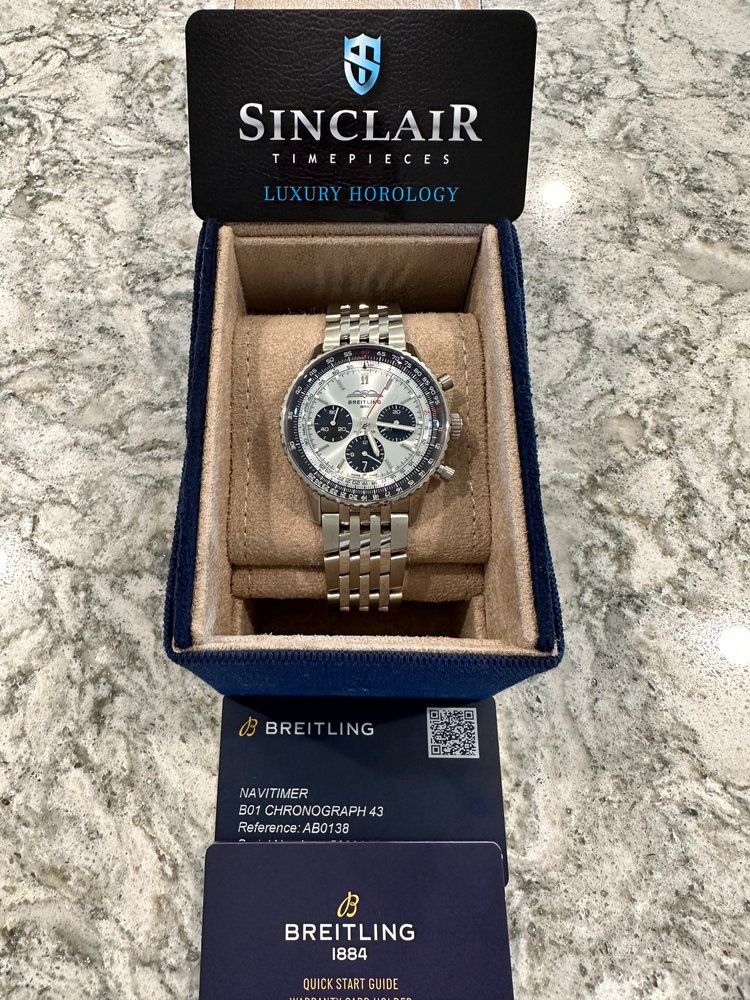 A breitling watch is in a box on a counter.