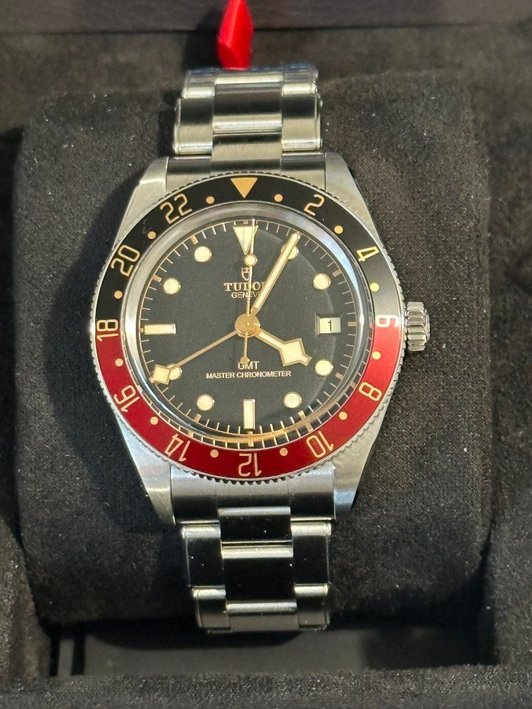 A tudor watch with a red and black face
