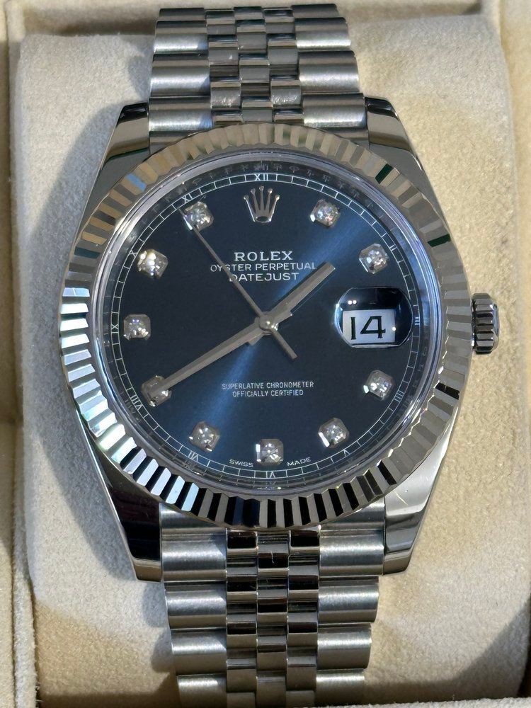 A silver rolex watch with a blue face and diamonds