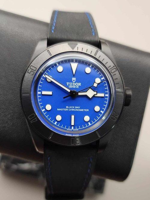 A tudor watch with a blue face and black band