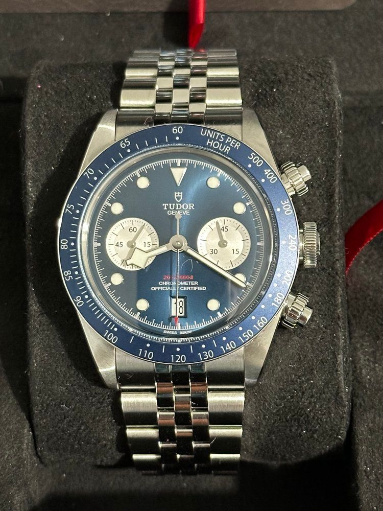 A tudor watch with a blue face and silver band