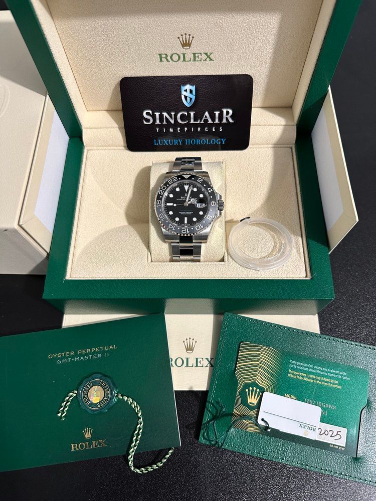 A rolex watch in a box with a sinclair card