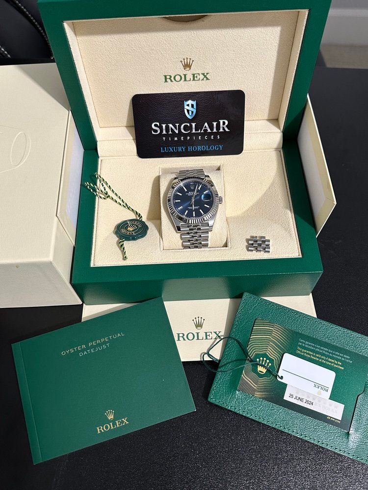 A rolex watch in a box with a sinclair card