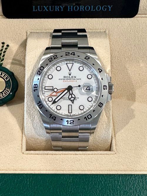 A silver rolex watch is sitting in a box