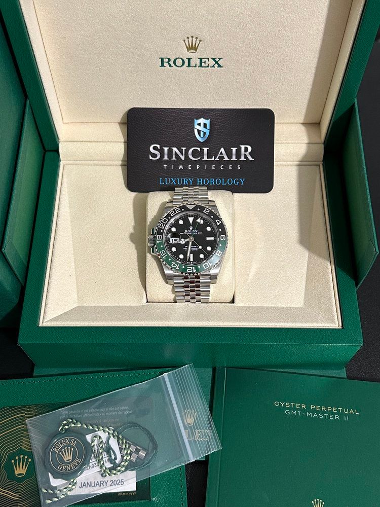 A rolex watch is in a green box with a sinclair card
