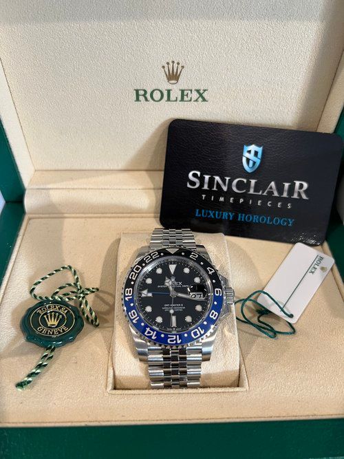 A rolex watch in a box with a sinclair certificate