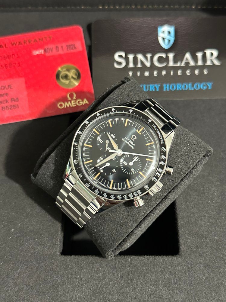 A sinclair watch sits on a black cushion