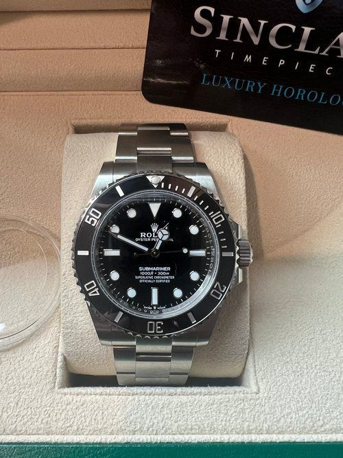 A rolex watch is on display with a sincla timepiece card