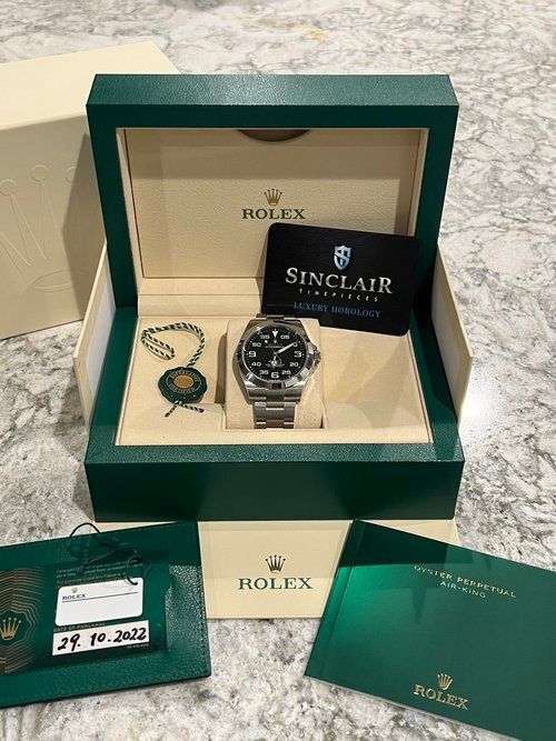 A rolex watch is in a box on a counter.