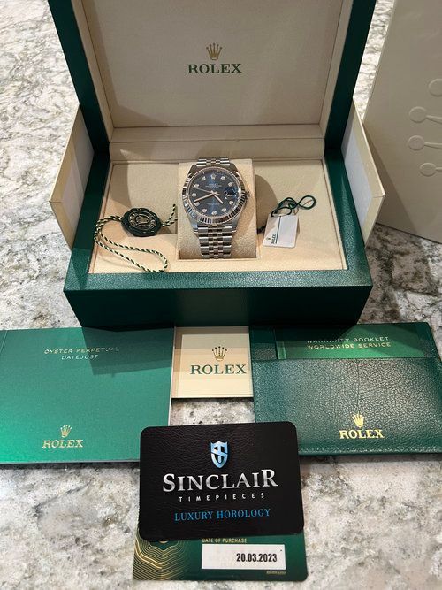A rolex watch is in a box with a certificate of authenticity.