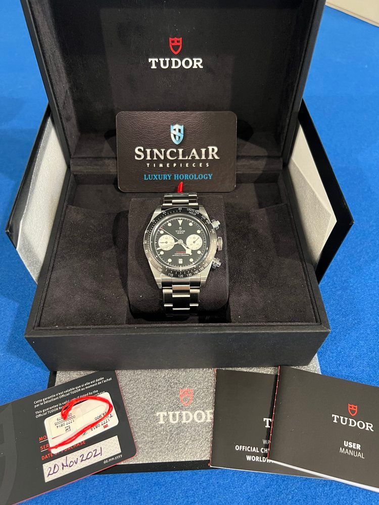 A sinclair watch sits in a black case
