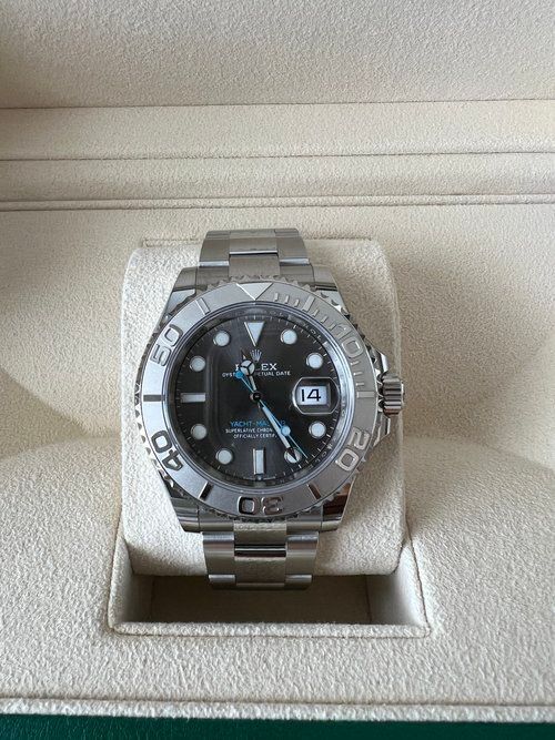 A rolex watch is sitting on a white display case.