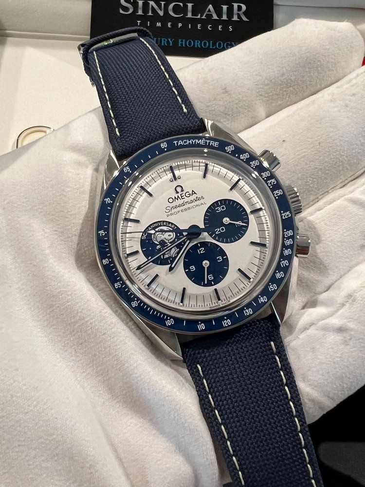 A person is holding a omega watch in their hand