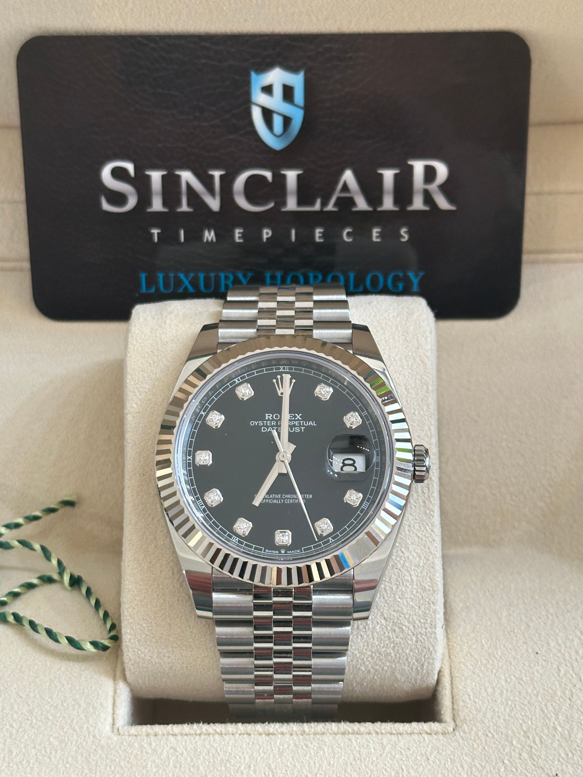 A rolex watch is sitting on top of a white cushion.