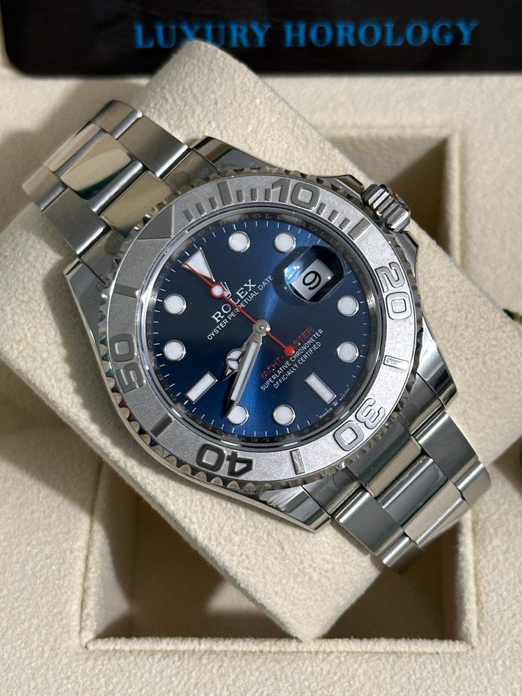 A silver and blue rolex watch sits in a box